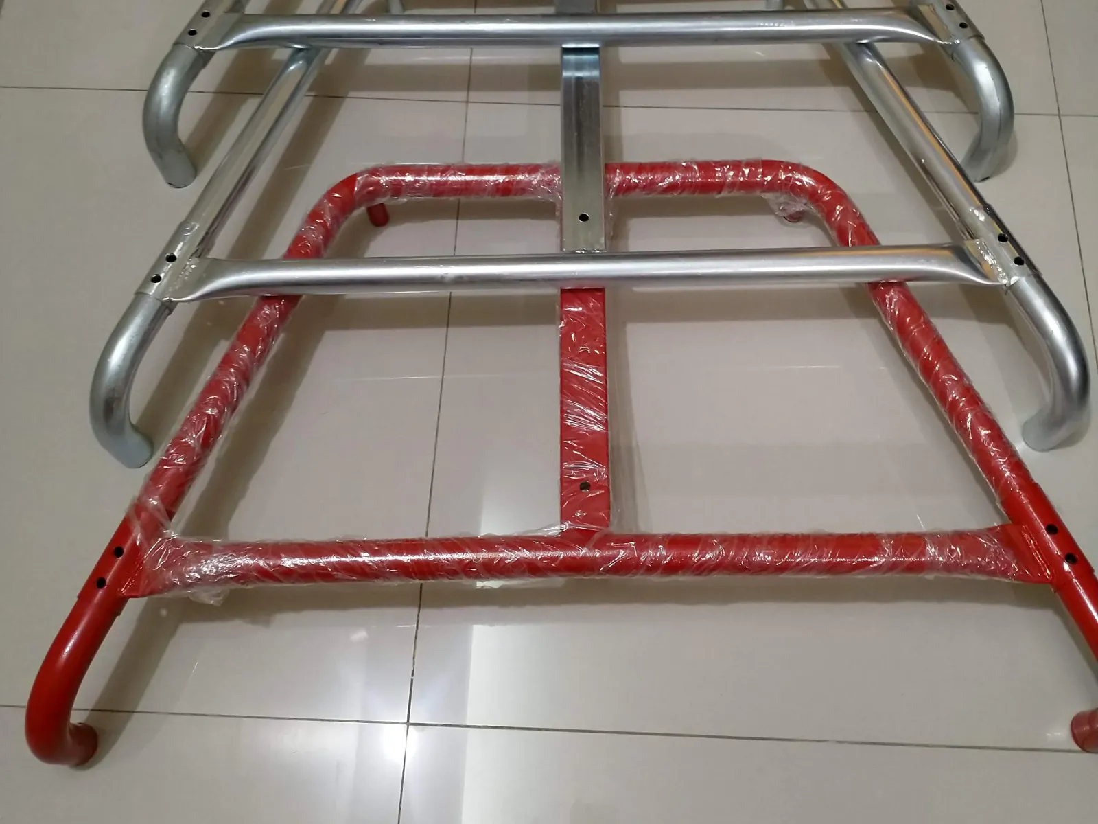 CNC bent tube base frames in zinc plated and red powder coated finishes